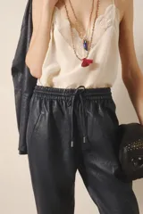Pantalón babucha de cuero ovino color negro, con bolsillos en el frente, cintura elastizada y tira de ajuste con terminales metálicas.