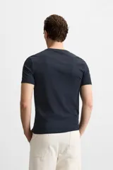 Camiseta slim fit de cuello redondo y manga corta, confeccionada en tejido de algodón con elasticidad.