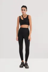 Top deportivo negro asimétrico con un solo tirante ancho y abertura en el pecho.