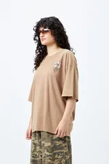 Remera azul con efecto gastado, corte holgado y estampado pequeño de flor en el pecho.