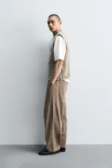 Pantalón cargo de algodón color marrón con efecto lavado, corte relajado y tiro medio. Presenta cintura elástica con botón y cierre de cremallera, bolsillos delanteros, bolsillos plastrón en la espalda y grandes bolsillos cargo en las perneras.