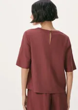 Blusa color beige de lino con mangas cortas y cuello redondo.