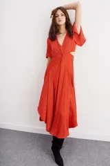 Vestido midi color naranja con escote en V, mangas cortas con volados, corte en la cintura con detalle de nudo y abertura en los laterales.