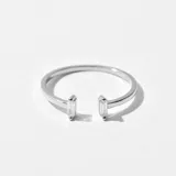 Anillo plateado con diseño minimalista y gemas en los extremos.