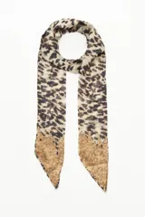 Pañuelo largo de poliéster con estampado animal print en tonos beige y negro.
