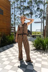 Conjunto tejido de dos piezas con rayas verticales en tonos marrón y negro. Incluye un chaleco sin mangas con botones y un pantalón de corte recto.