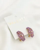 Par de aros dorados con forma de media luna, con incrustaciones de strass color lila.