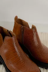 Botines negros de cuero con elástico lateral, detalle charol en el talón y suela track.