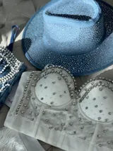Corset blanco con detalles de pedrería plateada, tiras removibles y espalda ajustable.