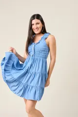 Vestido corto rojo con escote fruncido, tirantes anchos con volantes y cuerpo de nido de abeja. Falda con diseño escalonado.