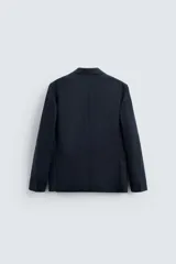 Blazer azul marino de lino, corte regular fit, con solapas de muesca, cierre de dos botones, bolsillo de vivo en el pecho, bolsillos de solapa en la cadera, aberturas en la espalda y puños con botones.