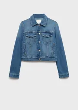 Chaqueta de jean celeste con cuello camisero, cierre frontal con botones metálicos, dos bolsillos de parche con solapa en el pecho y mangas largas con puños abotonados.