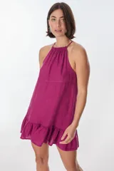 Vestido corto color fucsia, con cuello halter, corte suelto y ruedo con volados.