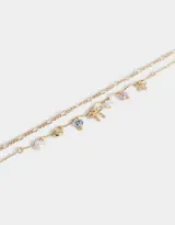 Collar corto dorado de doble cadena con dijes de cerámica, perlas, corazón y moño.