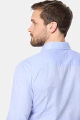 Camisa celeste de manga larga con cuello clásico y cierre con botones.