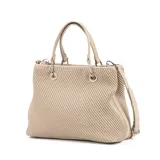 Cartera tipo shopper color taupe, confeccionada en símil cuero texturizado. Tiene doble asa de mano, correa bandolera regulable y herrajes plateados. El acceso es con cierre y cuenta con un compartimento principal con bolsillos internos, uno con cierre y dos abiertos.