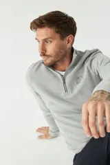 Buzo de felpa azul marino para hombre con medio cierre frontal, logo estampado en el pecho y puños. El modelo mide 1,80 m y usa talle M.