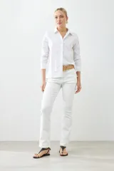 Camisa blanca de manga larga con cuello clásico y cierre frontal con botones.