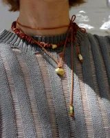 Collar regulable de bronce macizo con cuentas de piedra natural de cuarzo lima y jaspe rojo, y un dije central de labradorita.