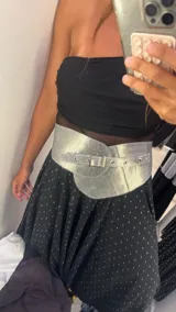 Vestido midi negro con estampado de lunares blancos, breteles finos y falda con volados y transparencias.