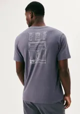 Camiseta blanca de algodón con cuello redondo y mangas cortas. Estampa rectangular con borde negro que contiene la frase "NATURAL ATMOSPHERE" en letras mayúsculas y una imagen de montañas y mar.