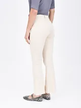 Pantalón de jean blanco, de corte recto y tiro alto, con terminación desflecada en el ruedo.