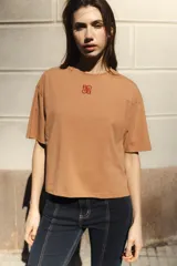 Remera negra de algodón con corte cuadrado, cuello redondo y logo bordado en color naranja.