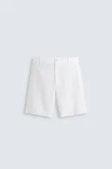 Bermuda blanca regular fit confeccionada en tejido con mezcla de algodón y lino. Cuenta con bolsillos frontales y traseros, cierre frontal con cremallera y botón.