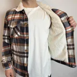 Chaqueta de franela a cuadros en tonos marrón, blanco, azul y naranja, con cuello de corderito blanco, cierre con botones a presión, bolsillos en el pecho con solapa y bolsillos laterales.