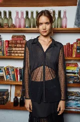 Camisa negra de tul elastizado, corte clásico y holgado, con cuello solapa, abotonada y mangas evasé muy largas para atar.