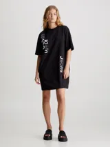 Vestido corto negro de corte recto, con cuello redondo y mangas cortas. Estampado vertical con el logo de Calvin Klein Jeans en color blanco.