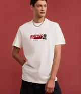 Remera de algodón color blanco, corte comfort, con cuello redondo y manga corta. Presenta un estampado grande en la espalda con un auto de carrera estilo Fórmula 1, un diagrama de circuito y varios textos gráficos relacionados con carreras.