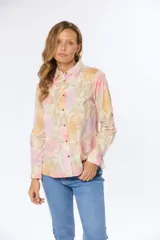 Camisa de manga larga con estampado floral en tonos rosa, naranja y lila. Confeccionada en lino y algodón, con cuello clásico, cierre frontal con botones y puños abotonados.