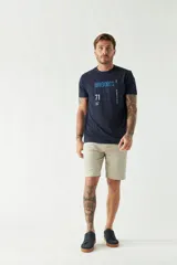 Remera blanca de algodón con estampado frontal que incluye texto en color rojo, amarillo y azul.