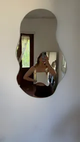 Top blanco de ecocuero con breteles dorados y corte irregular.