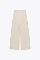 Pantalón de algodón color beige, de tiro medio, pierna ancha y cintura elastizada.