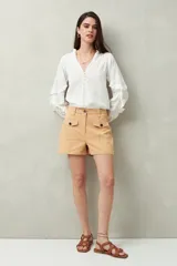Short blanco de tiro alto con bolsillos delanteros con solapa y botones a la vista.