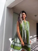 Vestido corto verde con estampado de líneas blancas, cuello en V y botones.