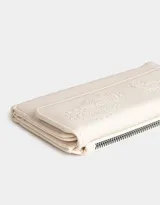 Billetera negra de cuerina con formato fichero y solapa bordada. Cuenta con sistema de apertura con broche a presión y compartimentos para tarjetas y billetes.