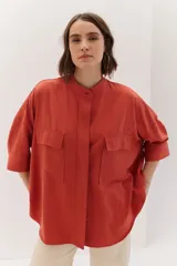 Sobrecamisa celeste de corte recto, con cuello mao, mangas 3/4 con puños y cierre frontal con botones. Tiene dos bolsillos de parche en el pecho.