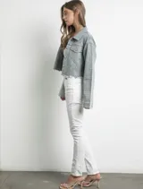 Campera de jean celeste con cuello clásico, cierre frontal con botones metálicos y dos bolsillos con solapa en el pecho. Está decorada con strass plateados en toda la superficie y tiene terminaciones desflecadas.