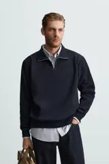 Sudadera azul marino de cuello alto con cierre frontal de cremallera, corte relaxed fit, manga larga y terminaciones en rib.
