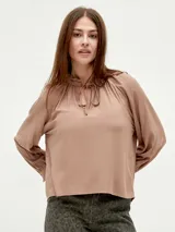 Blusa color lavanda con cuello fruncido y lazo.