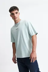 Remera azul de corte holgado con estampa en la espalda de una galleta y un cartón de leche con el texto "Cookies & Milk".
