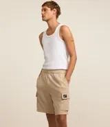 Bermuda masculina color beige confeccionada en tela french terry, con cintura elástica, cordón interior para ajustes y bolsillos cargo.