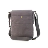 Matera de canvas color negro, combinada con símil cuero marrón. Cuenta con tapa, broches magnéticos, bolsillo tipo guantera bajo la tapa, división interna con velcro para usar como morral y bolsillo trasero con broche magnético. Incluye correa larga regulable.