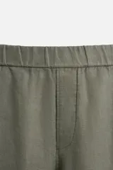 Pantalón negro regular fit confeccionado en tejido de lino. Cintura ajustable con cordón interior, bolsillos frontales y detalle de bolsillos traseros de vivo.