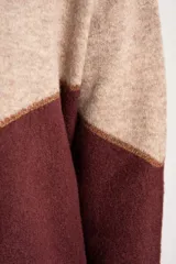 Sweater de tejido de punto con diseño de bloques de color en tonos beige, blanco roto y bordó. Presenta cuello redondo y mangas largas.