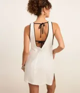 Vestido corto de playa confeccionado en viscolino color crudo, con sisas profundas, escote en V y detalle de vieses contrastantes en color negro.