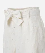 Short de tiro alto color crema, con trabillas en la cintura, cinturón de tela para lazo, elástico en la espalda, cierre por cremallera y detalles de lentejuelas bordadas.